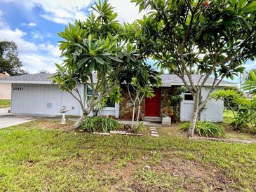 Single story home with red door and landscaping at 20437 Midway Blvd, Port Charlotte, FL 33952