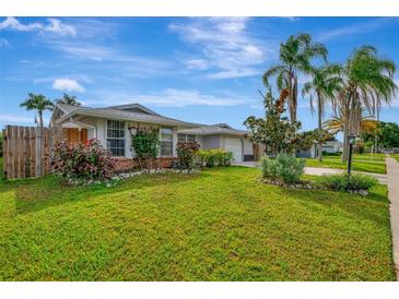 Single story home with a large green lawn, palm trees, and fenced backyard at 3917 Cochise Ter, Sarasota, FL 34233