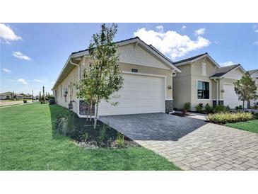 Charming single-story home featuring a two-car garage and a well-manicured front yard with stone driveway at 18824 Dayspring Pl, Venice, FL 34293