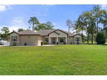 Single-story home with a well-manicured lawn at 11358 Lomita Wren Rd, Weeki Wachee, FL 34614