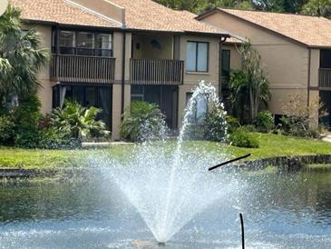Condo building overlooks a lake with fountain and mature tropical landscaping with screened in balcony at 3810 75Th W St # 116, Bradenton, FL 34209