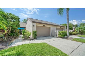 Two-car garage with attached walkway and landscaping at 5956 Clubside Dr, Sarasota, FL 34243