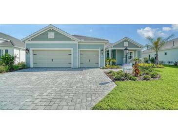 Two-car garage home with paver driveway and landscaping at 21281 Holmes Cir, Venice, FL 34293