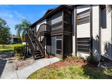 Exterior view of a two-story condo building with stairs and a screened-in porch at 3809 59Th W Ave, Bradenton, FL 34210