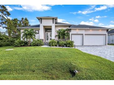 Modern two-story house with a two-car garage and manicured lawn at 14219 Wenzel Ave, Port Charlotte, FL 33981
