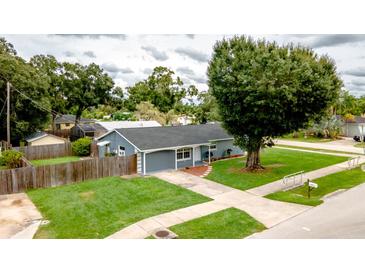 House with gray exterior, green lawn and driveway at 4573 Mcintosh Ln, Sarasota, FL 34232