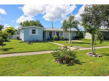 Charming light blue home with a covered porch and manicured lawn at 22119 Laramore Ave, Port Charlotte, FL 33952