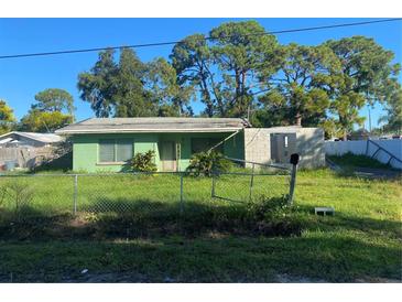 Small green house with damaged roof and overgrown yard at 108 Sago Ln, Nokomis, FL 34275