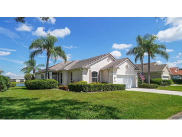 One-story house with a well-manicured lawn and palm trees at 4043 Caddie E Dr, Bradenton, FL 34203