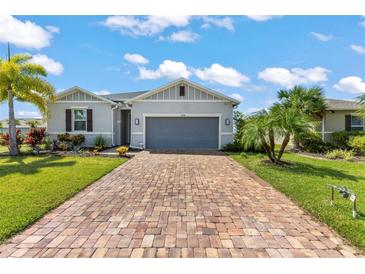 Modern house exterior with gray garage door and paver driveway at 7434 35Th E Ln, Sarasota, FL 34243