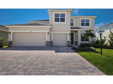 Charming two-story home featuring a paved driveway, a two-car garage, and manicured landscaping at 4322 Silo Port Ct, Lakewood Ranch, FL 34211