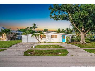 Charming single story home with a blue door and spacious yard at 21288 Edgewater Dr, Port Charlotte, FL 33952
