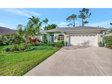 Charming single-story home with well-manicured lawn, lush landscaping, and a two-car garage at 7235 Rangi Dr, Sarasota, FL 34241