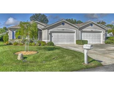 Charming single-story home featuring a manicured lawn and attached two-car garage at 1362 Hedgewood Cir, North Port, FL 34288