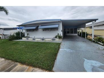 Single-wide manufactured home with carport and lawn at 5317 Chateau Ln, Bradenton, FL 34207