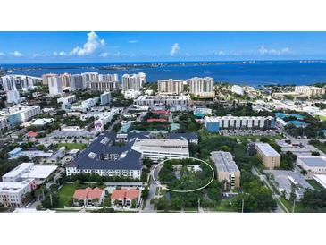 Aerial view of a house and surrounding neighborhood, showcasing the property's location and proximity to other buildings at 1569 7Th St, Sarasota, FL 34236
