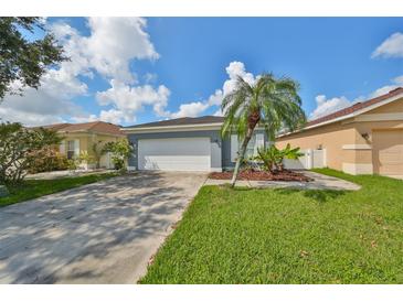 Single-story house with attached garage, landscaped yard, and palm tree at 2309 29Th E Ave, Palmetto, FL 34221