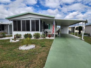 Mobile home with carport and landscaped yard at 5530 Denmark Dr, Bradenton, FL 34207