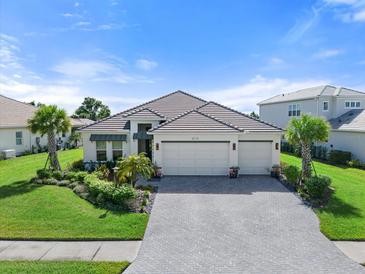 Home with three-car garage, landscaped yard, and paver driveway at 729 Tailwind Pl, Sarasota, FL 34240