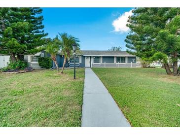 Charming ranch home with gray exterior, white fence, and manicured lawn at 4653 Orlando Cir, Bradenton, FL 34207