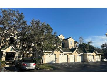 Exterior view of condo building with garages and landscaping at 5146 Northridge Rd # 209, Sarasota, FL 34238