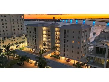 Luxury condo building with waterfront views and sunset at 226 Golden Gate Pt # 64, Sarasota, FL 34236