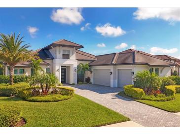 Luxury home with three-car garage and manicured landscaping at 7928 Mainsail Ln, Sarasota, FL 34240