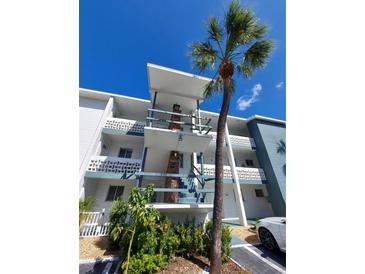 Exterior view of a condo building with palm trees and landscaping at 1837 Flamingo Blvd # O35, Bradenton, FL 34207