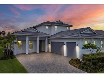 Two-story home with gray double-car garage and landscaped yard at 8175 Redonda Loop, Lakewood Ranch, FL 34202