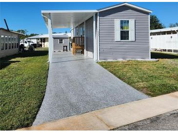 Newly constructed manufactured home with carport and paved driveway at 6421 Kilohee Ct, North Port, FL 34287