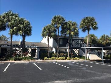 Condo complex featuring palm trees, ample parking, and well-maintained landscaping at 7234 Cloister Dr # 7234, Sarasota, FL 34231