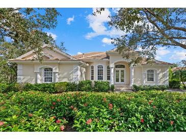 Charming single-story home with a well-manicured lawn and colorful flowering bushes at 7319 Westminster Ct, University Park, FL 34201