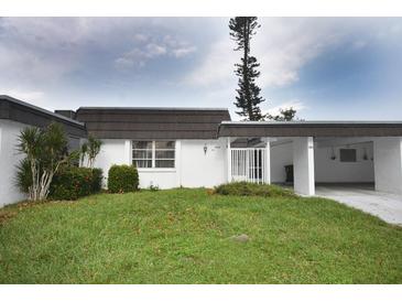 Front view of a villa with a carport and well-maintained lawn at 3961 Ashwood Ln # 44, Sarasota, FL 34232