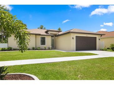 Single-story home with two-car garage, landscaped lawn, and a well-maintained yard at 2471 W Price Blvd, North Port, FL 34286