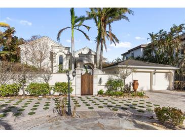 Elegant home exterior with gated entry and lush landscaping at 8213 Midnight Pass Rd, Sarasota, FL 34242