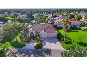 Inviting home with a manicured lawn and a paver driveway leading to a two-car garage at 2921 Seasons Blvd, Sarasota, FL 34240