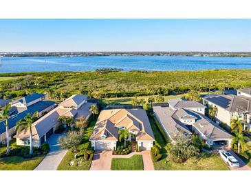 Stunning aerial view of a single-Gathering home with a tile roof and a beautiful waterfront backdrop at 5130 Tidewater Preserve Blvd, Bradenton, FL 34208