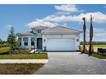 Beautiful single-story home showcasing a three car garage and manicured front lawn at 7661 Moonbeam Ave, Sarasota, FL 34241