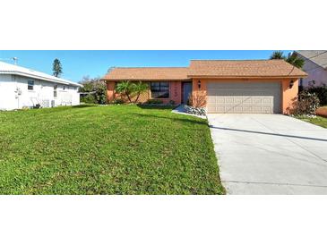 Charming ranch home with a well-maintained lawn and attached garage at 723 Portia N St, Nokomis, FL 34275