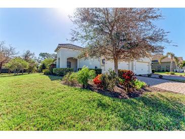 One-story home with a landscaped yard and a two-car garage at 1269 Backspin Dr, Englewood, FL 34223