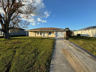 Ranch-style house with a paved driveway and yard at 10294 Reims Ave, Englewood, FL 34224