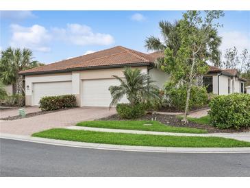 Two-car garage home with attractive landscaping and brick paver driveway at 9869 Haze Dr, Venice, FL 34292