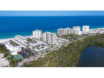 Stunning aerial view of beachfront condos with beautiful blue ocean and lush landscape at 2100 Benjamin Franklin Dr # 205, Sarasota, FL 34236