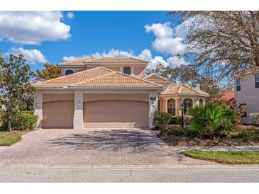 Charming two-story home with a three-car garage, tile roof, and well-maintained landscaping at 650 Crane Prairie Way, Osprey, FL 34229