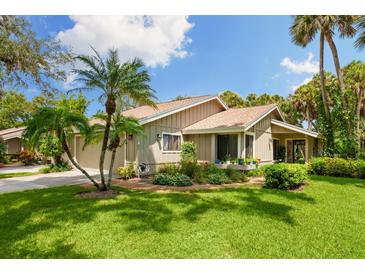 Tan house with brown roof, nicely landscaped lawn and palm trees at 7547 Silver Fern Blvd # 54, Sarasota, FL 34241