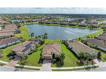 Stunning aerial view of a lakeside community with well-maintained lawns and beautiful tile-roofed homes at 6547 Willowshire Way, Bradenton, FL 34212
