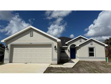 New construction home with a two-car garage and neutral exterior at 890 Indus Rd, Venice, FL 34293