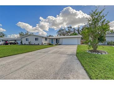 Ranch-style home with a two-car garage and landscaped yard at 3442 Fairview Dr, Sarasota, FL 34239