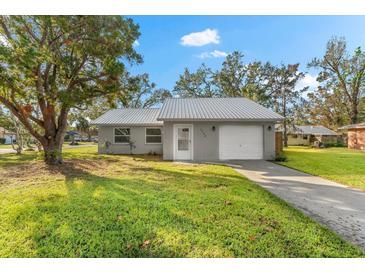 Newly renovated single story home with metal roof and landscaped yard at 2382 Spring Oaks Ct, Sarasota, FL 34234