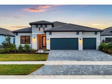 Two-story home with gray exterior, three-car garage, and landscaped front yard at 8983 Baroque Ter, Sarasota, FL 34240